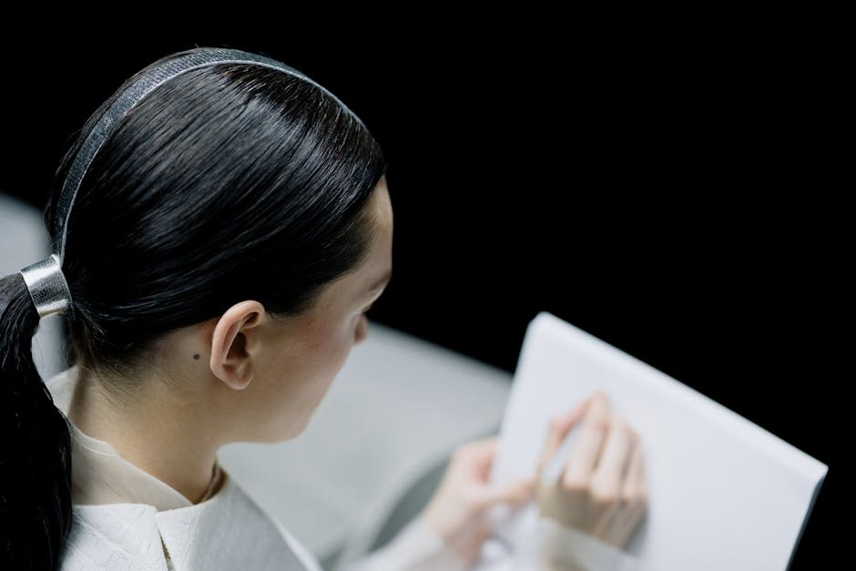 Woman with sleek hairstyle taking notes in a futuristic setting.