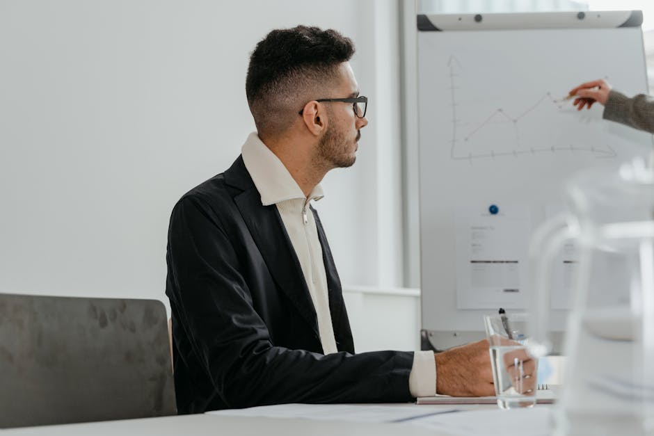 Professional male analyzing growth chart during modern office meeting session.