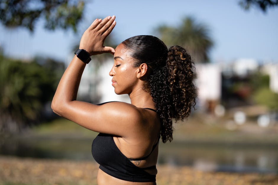 Side view of a woman meditating outdoors in a yoga pose, embracing tranquility.