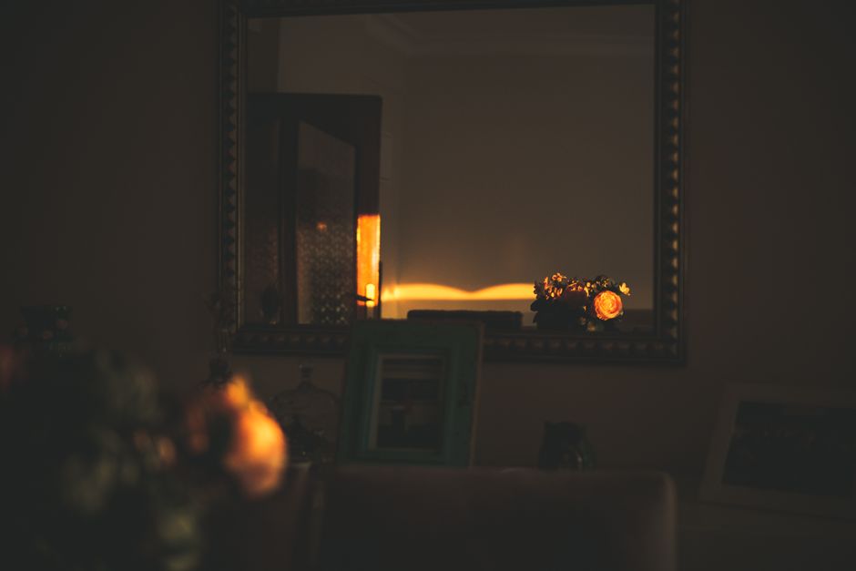 A warm and inviting interior room with a glowing mirror reflection at dusk.