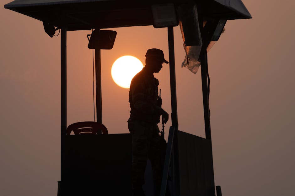 Silhouette of a soldier standing guard in Lucknow at sunset, with striking sun backdrop.