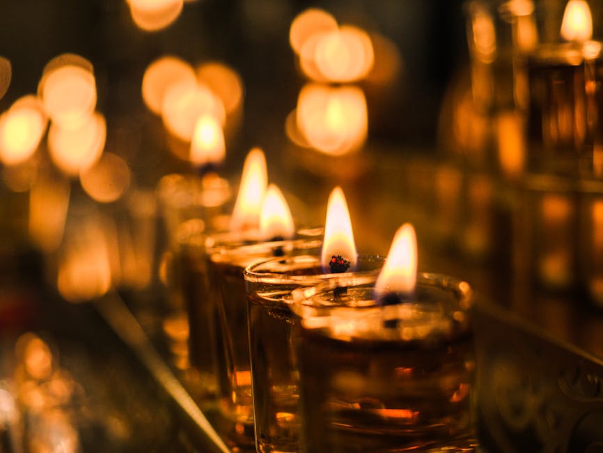A row of glowing candles with flickering flames creates a warm and serene atmosphere.