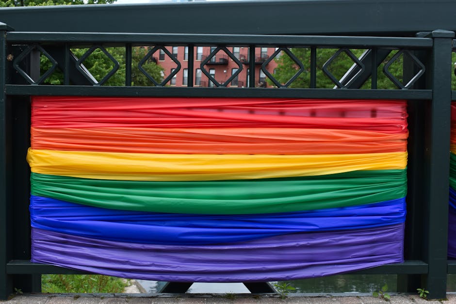 A vibrant city bridge adorned with rainbow fabric symbolizing diversity and pride.