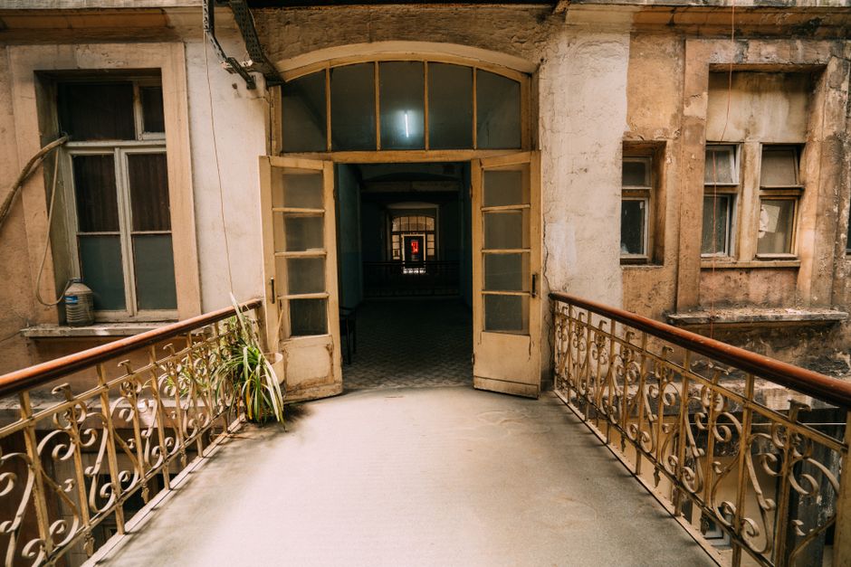 Explore the charm of a rustic, abandoned building with an open doorway and intricate railings.