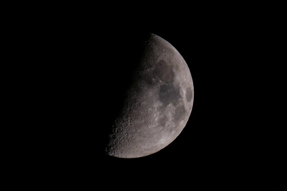 Stunning close-up image of the first quarter moon against a clear black sky, highlighting lunar features.