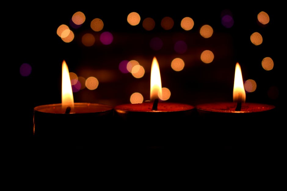 Close-up of three lit candles with a warm bokeh background, creating a peaceful and calming atmosphere.