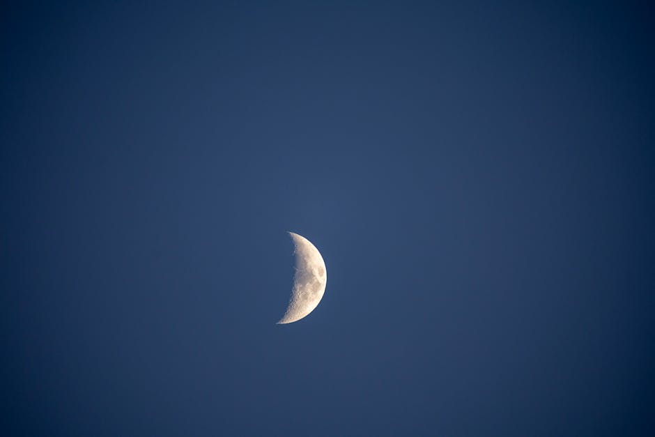 A clear view of the crescent moon set against a deep blue night sky, capturing celestial beauty.
