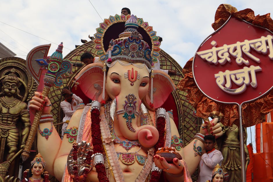 Colorful Ganesh idol with festive decorations during a traditional Ganesh Chaturthi street parade.