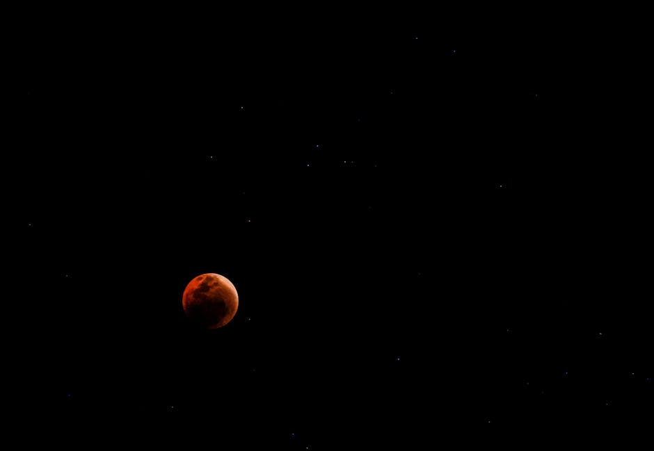 Captivating image of a blood moon with scattered stars in the night sky.