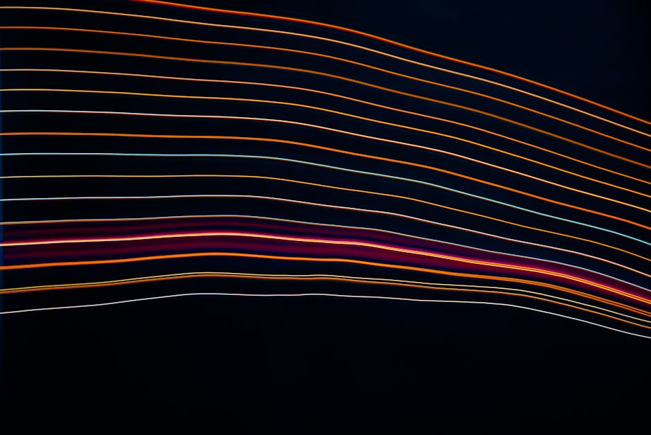 Colorful abstract lines of light create a dynamic pattern on a dark background.