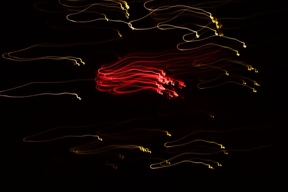 Colorful abstract light trails create an energetic and dynamic pattern on a dark backdrop.