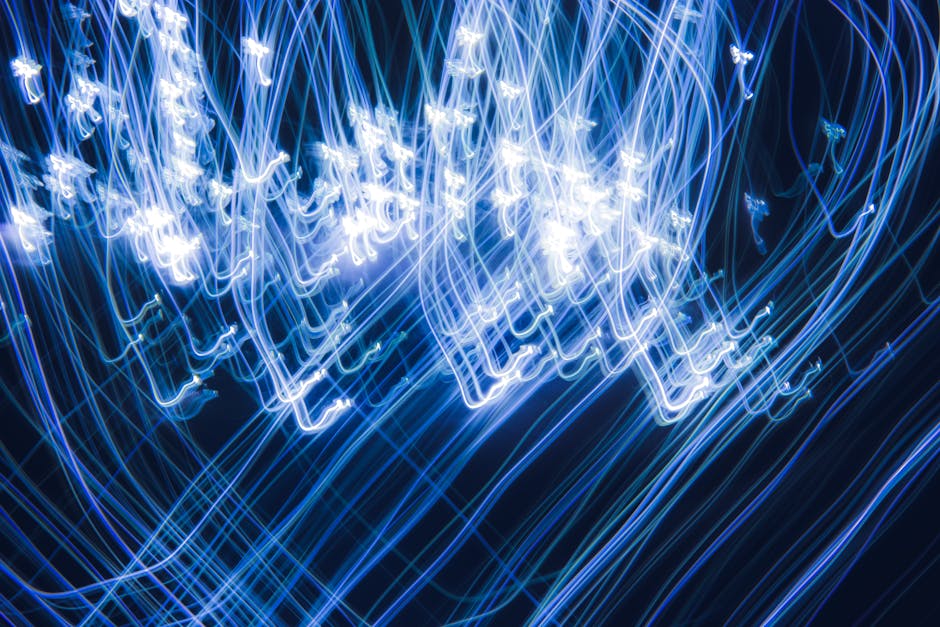 Vibrant abstract light trails creating dynamic blue patterns in darkness.