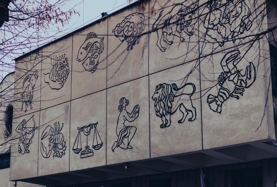Outdoor mural depicting zodiac signs on a building wall in Chrzanow, Poland.
