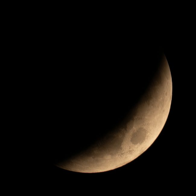 Detailed close-up of the crescent moon against a dark sky, capturing lunar textures.