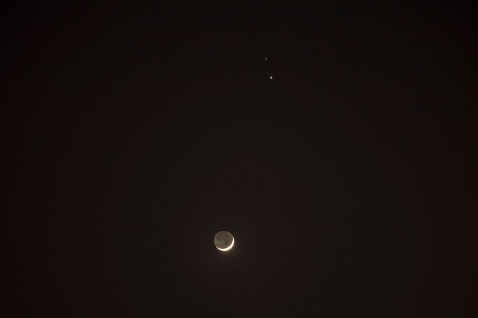 A beautiful crescent moon and distant stars in a dark night sky, offering a serene celestial view.