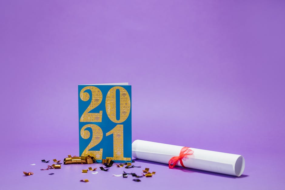 Graduation themed setup with a 2021 card, diploma, and confetti on a purple background.