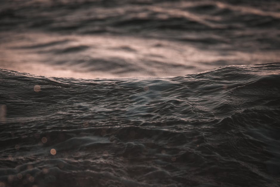 Capture the tranquility of ocean waves at dusk, highlighting the texture of ripples on water