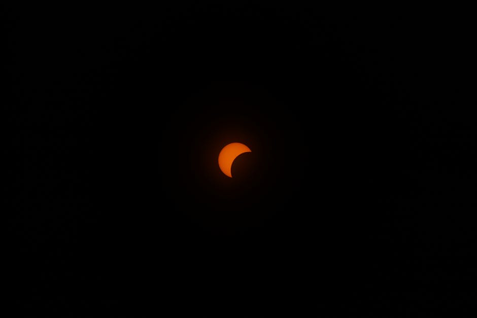 A striking partial solar eclipse in a dark sky, highlighting the sun's crescent shape.