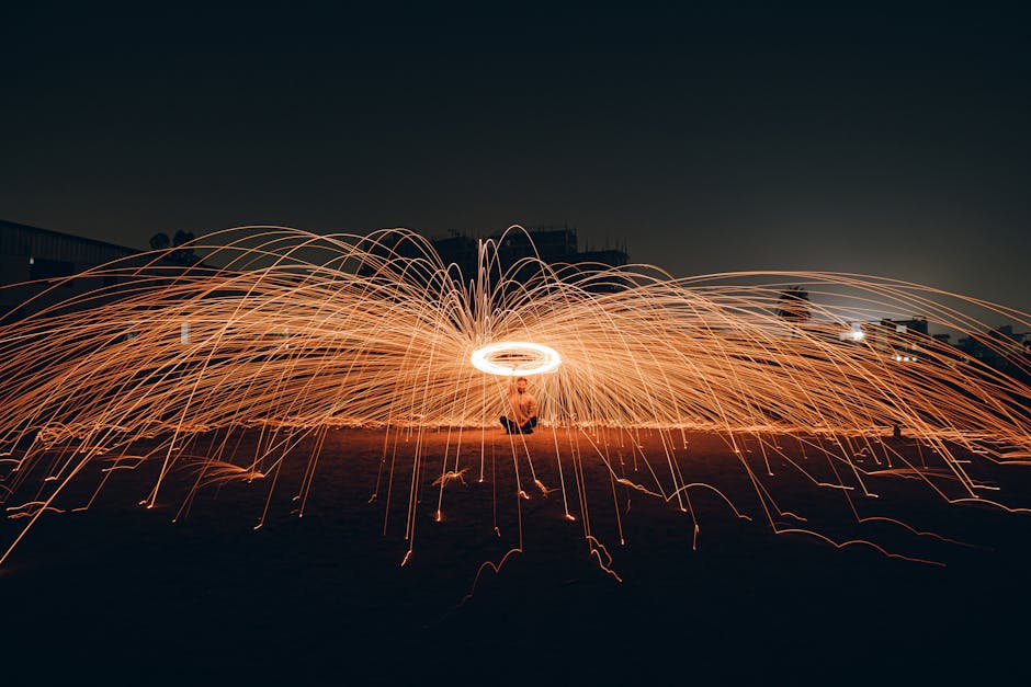 Mesmerizing long exposure shot of spinning sparks creating a dazzling light show at night.
