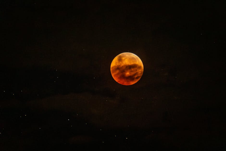 Capture of a vivid blood moon with stars in a dark night sky.