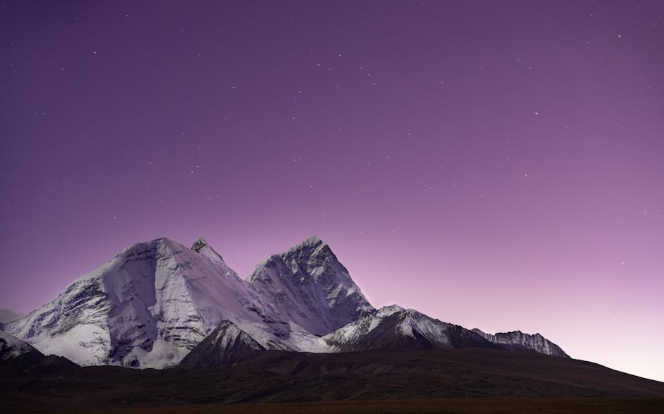 Snow-covered mountains under a serene purple twilight sky, perfect for nature enthusiasts.