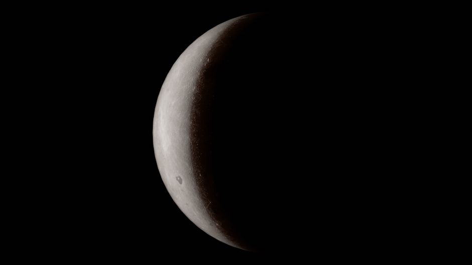 A detailed close-up of a crescent moon against a deep black space background.