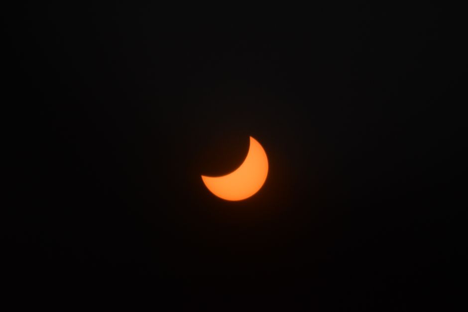 A captivating view of a crescent solar eclipse against a dark sky.