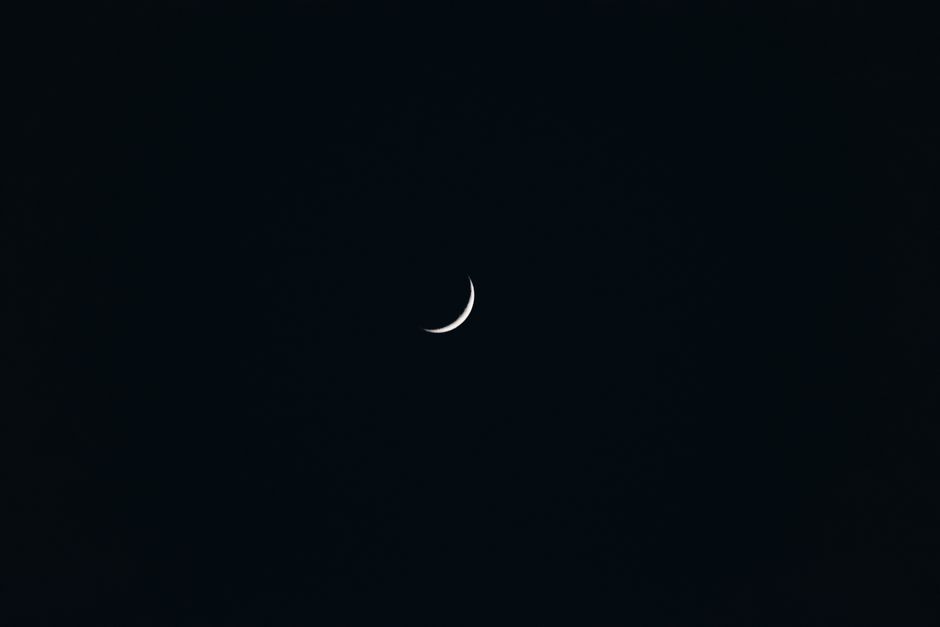 A captivating crescent moon against a dark sky, showcasing minimalist celestial beauty.