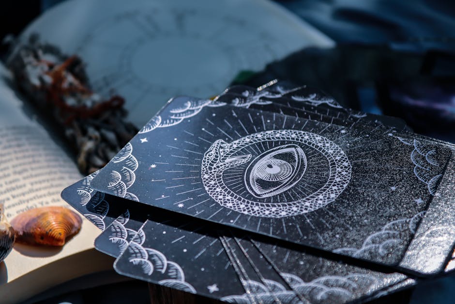 A captivating close-up of tarot cards beside an open book, embodying the mystery of fortune telling.