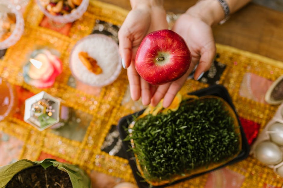 Colorful Haftsin table setup featuring a red apple, symbolizing beauty and health for Nowruz.