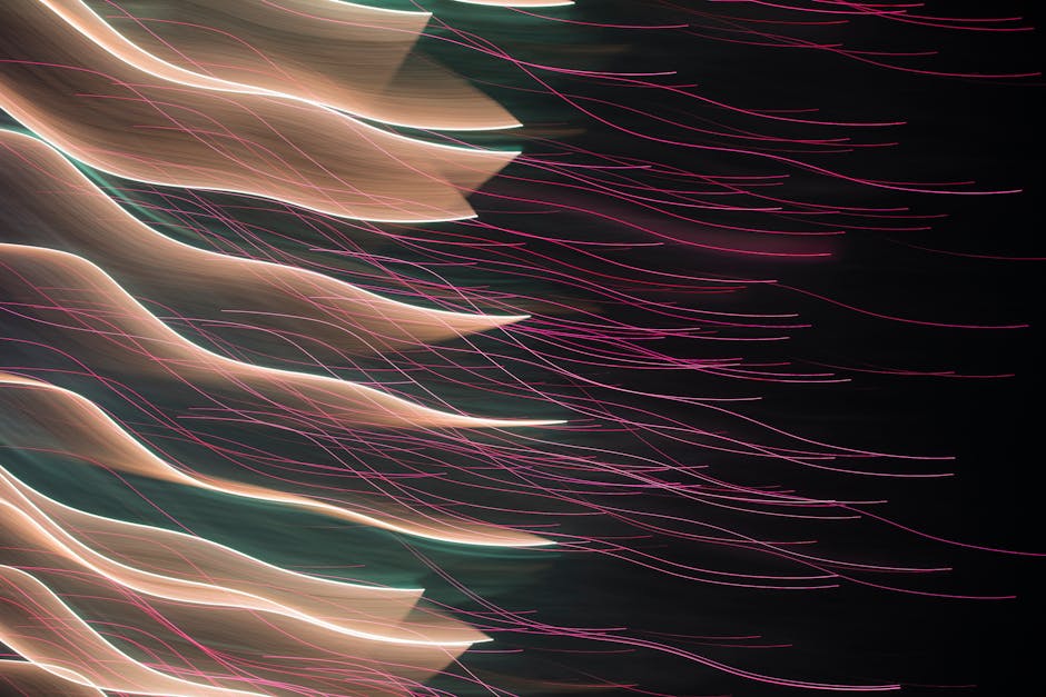 Colorful abstract light trails creating a dynamic visual effect against a dark backdrop.