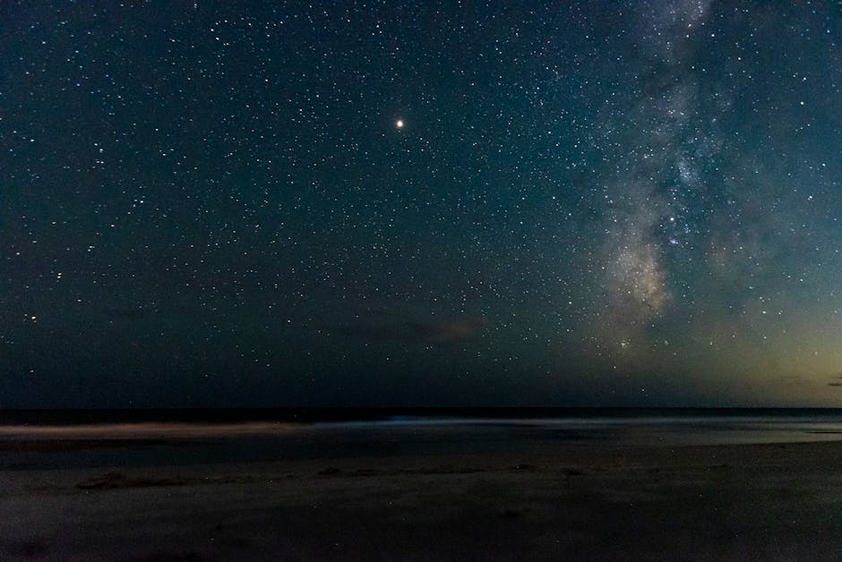 Captivating view of the Milky Way and stars over a tranquil seaside at night.