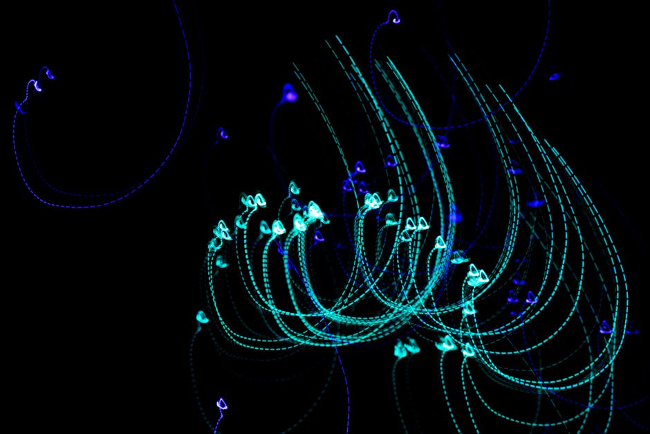 Dynamic light painting with blue and green trails creating abstract patterns against a black background.