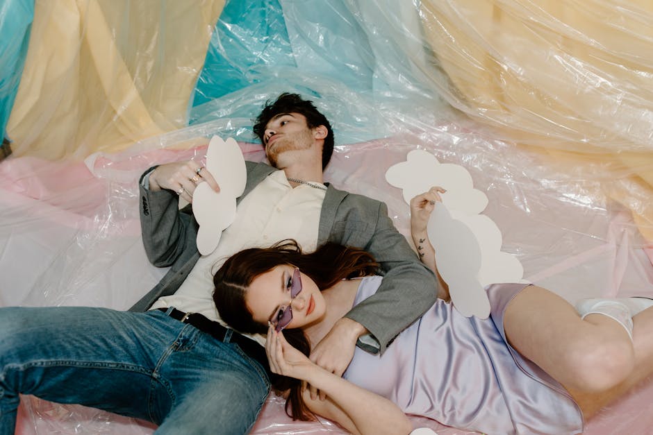 A couple relaxing indoors with creative paper clouds and colorful backdrop, embracing tranquility.