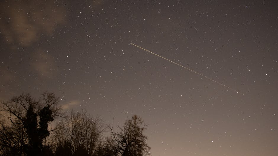 Captivating view of a starry night sky with a shooting star over Thun, Switzerland.