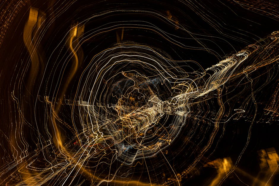 Swirling light trails create an abstract pattern against a dark background, evoking motion and energy.