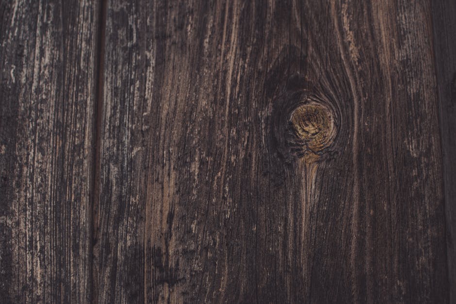 Detailed view of a dark wooden surface showcasing natural grain patterns and rich, earthy tones.