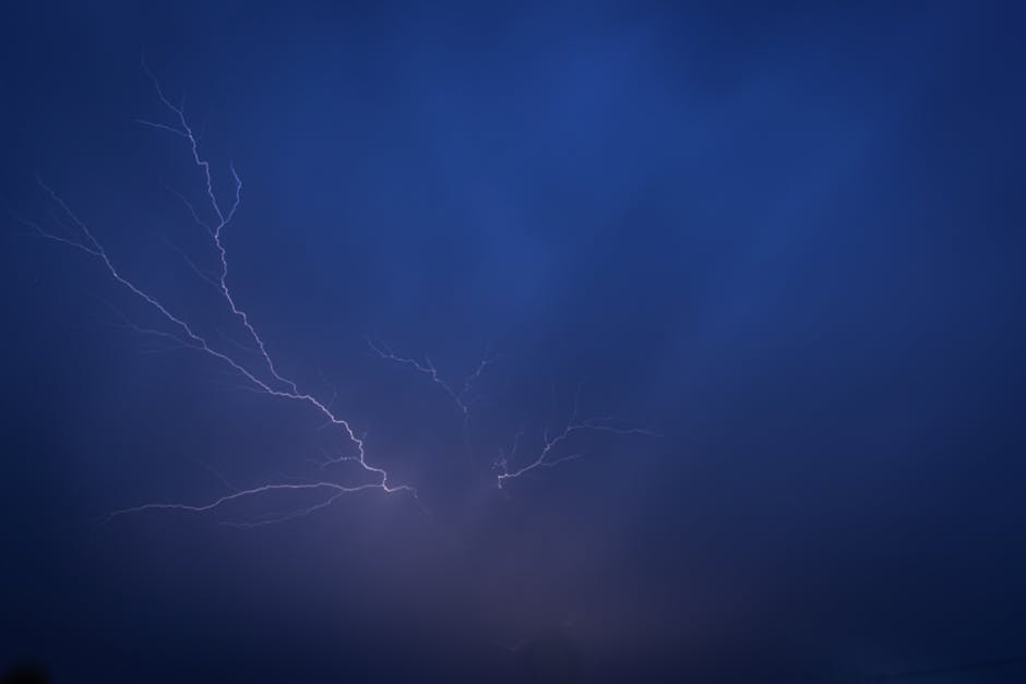 A striking lightning bolt illuminates the night sky, creating a dramatic and powerful visual effect.