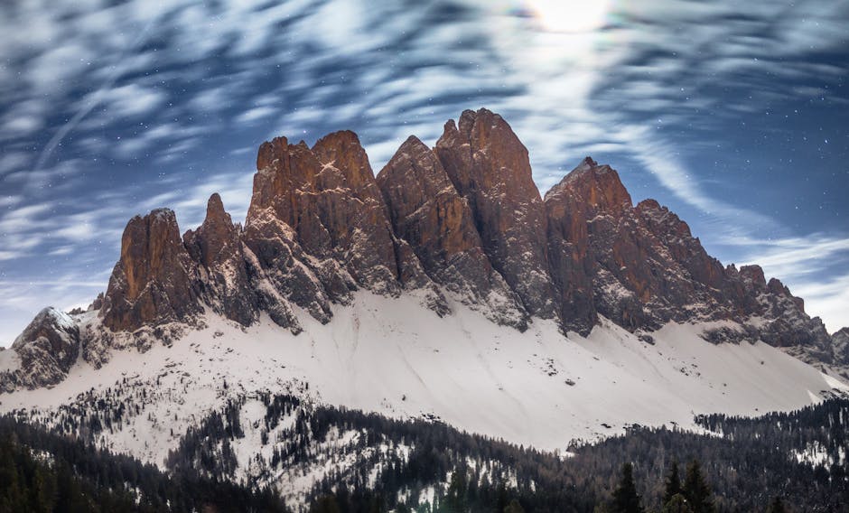 Majestic snow-covered Dolomites under a starry night sky, capturing serene winter beauty.