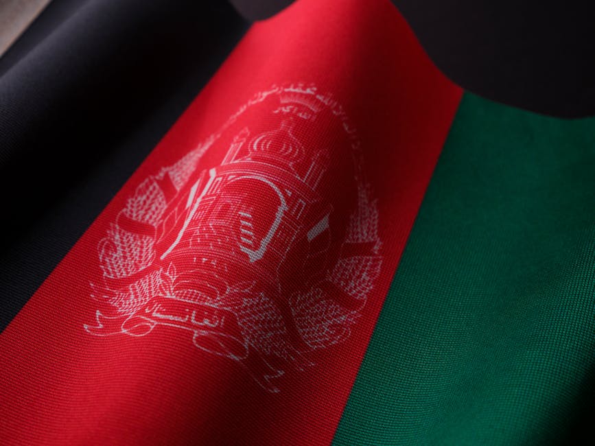 Detailed photograph of the Afghan flag showcasing its vibrant colors and emblem. Perfect for cultural and political themes.