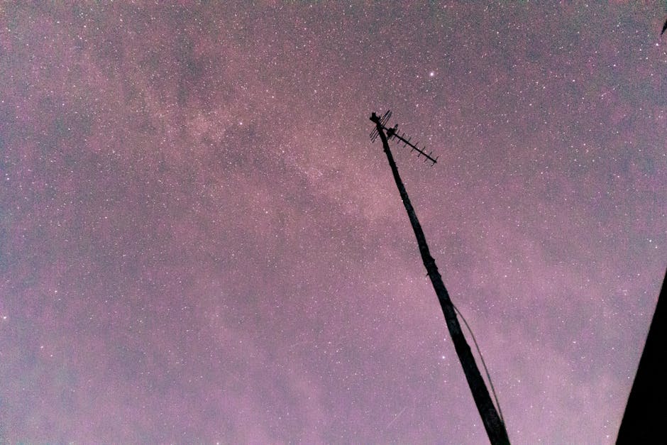 A star-filled night sky with a silhouetted antenna, showcasing the beauty of astronomy.