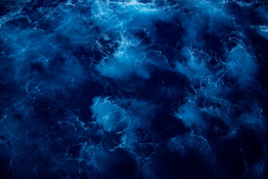 Captivating dark blue ocean waves with dynamic wavy textures and striking contrast.