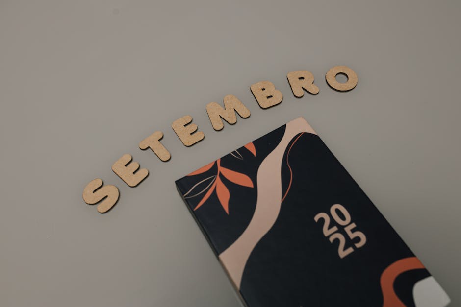 Stylish 2025 planner with abstract cover and 'Setembro' spelled out in wooden letters.