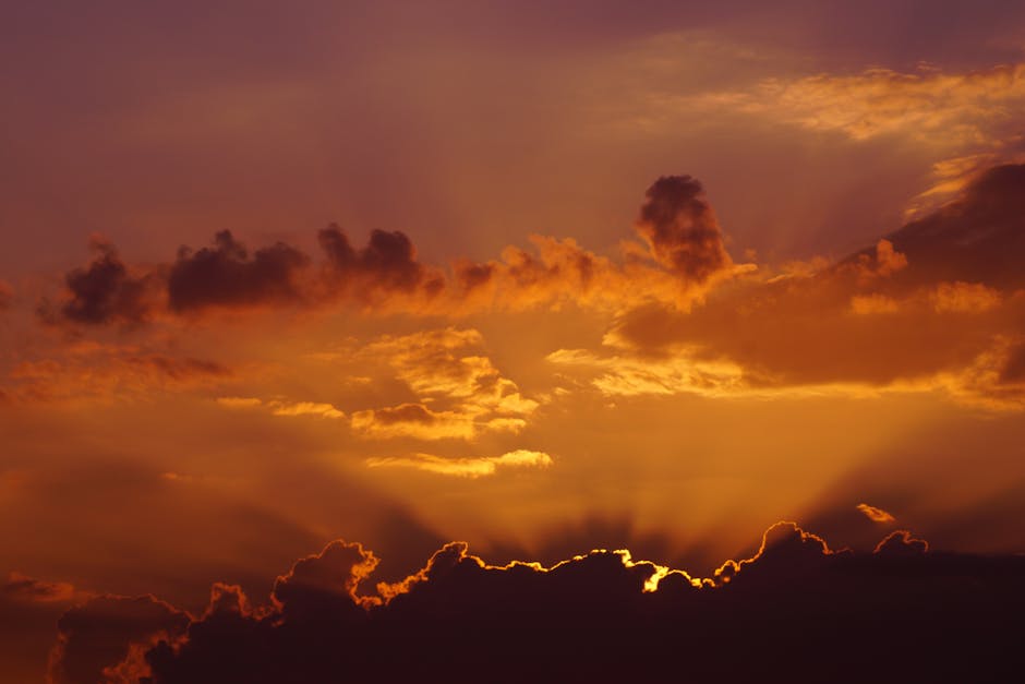 Capture of a breathtaking sunrise with dramatic golden clouds and radiant light beams.