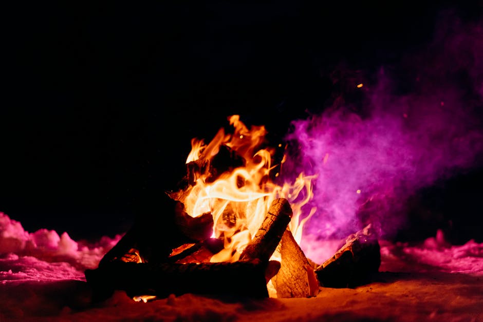 A lively winter bonfire illuminating the snow and creating a warm contrast against the dark night sky.