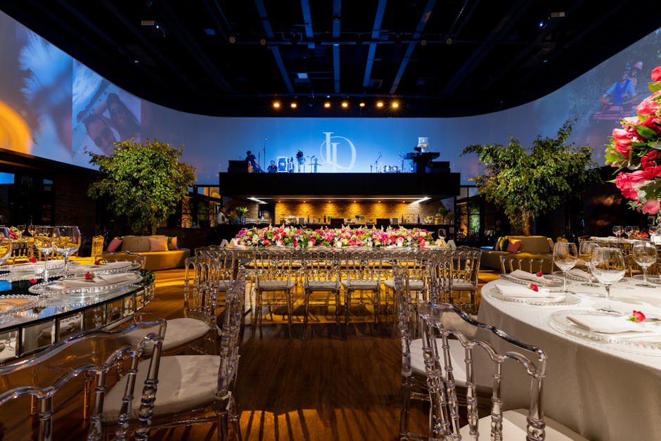 Luxurious indoor wedding reception with elegant table settings, floral arrangements, and ambient lighting.