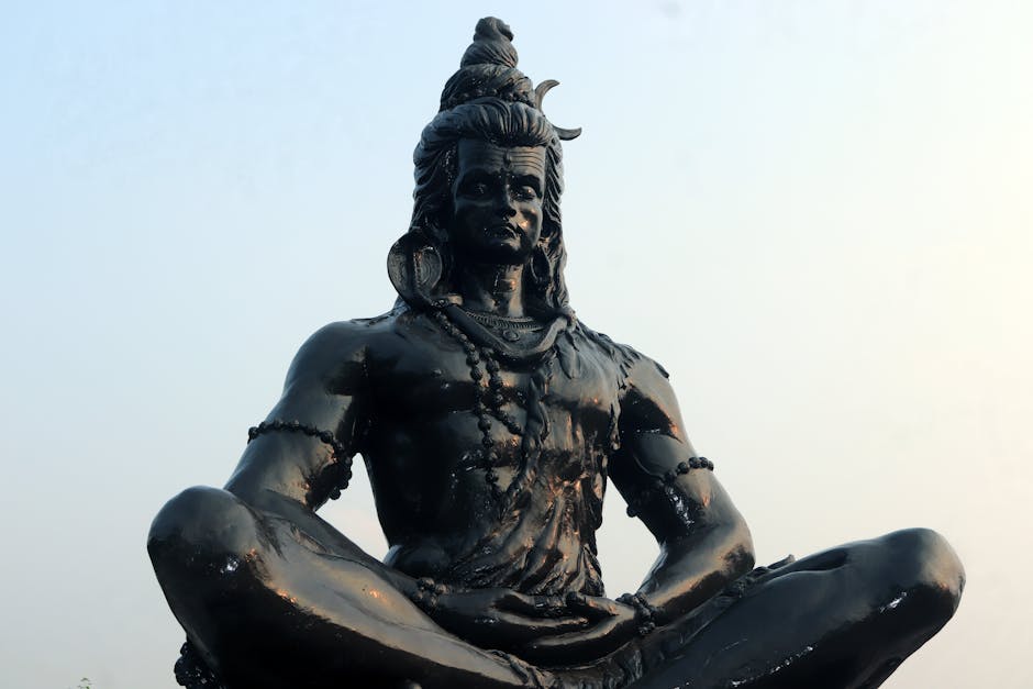 A black statue of Hindu deity Shiva meditating cross-legged in Cuttack, India.