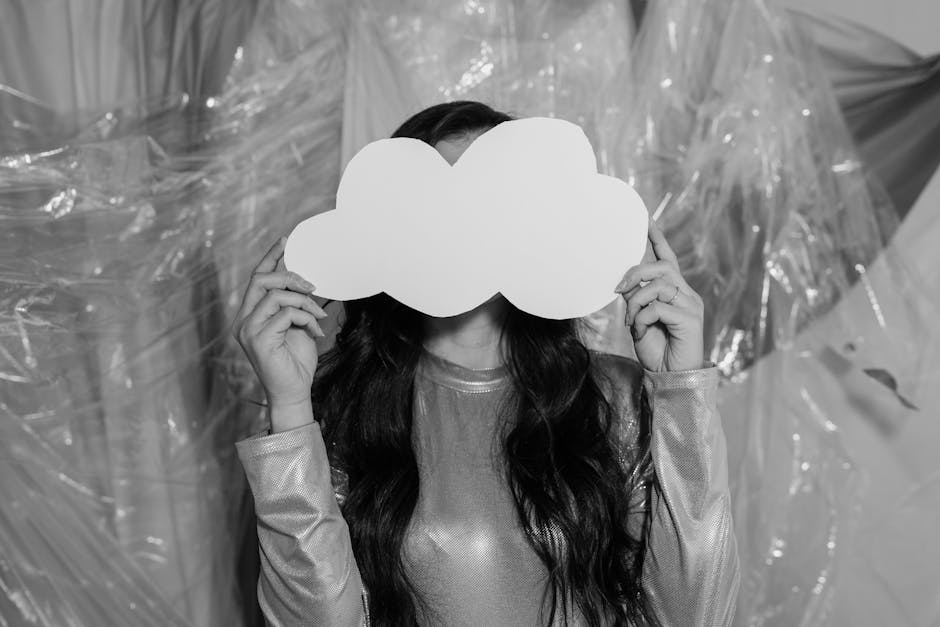 Artistic black and white portrait with a mysterious touch of a paper cloud mask.