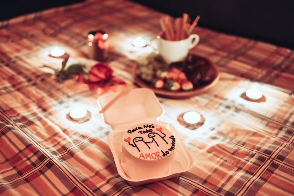 Intimate dining scene with candles, a declaration of love, and a dessert on a plaid tablecloth.