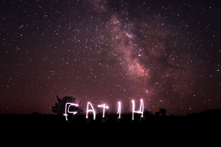 Stunning night sky with stars and light painting spelling 'faith'.